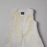 White textured garment with a brand label on a tiled floor